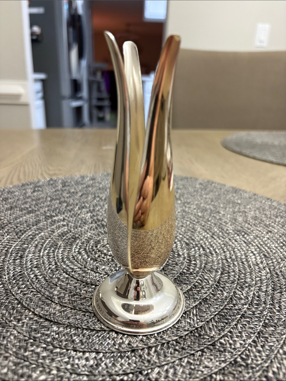 elegant silver-colored metal vase shaped like a tulip, with a brilliant polished